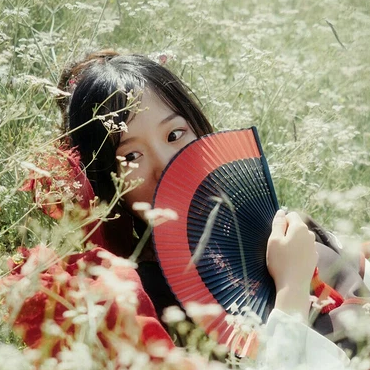 花叢中帶折扇女生頭像，唯美古風真人頭像
