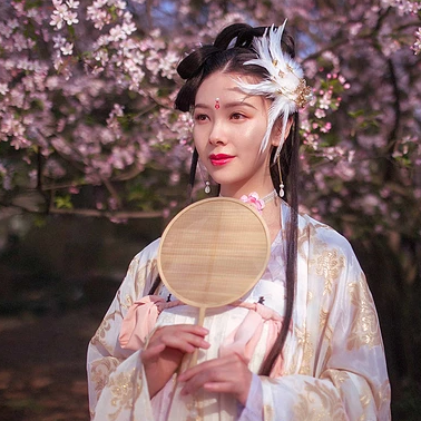 粉色桃花拂面帶團扇女生頭像，唯美古風(fēng)真人頭