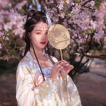 粉色桃花拂面帶團扇女生頭像，唯美古風(fēng)真人頭
