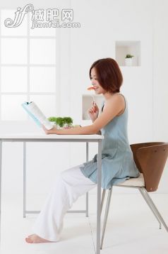 人,椅子,連衣裙,生活方式,影棚拍攝_563946157_Young woman reading a book and eating with smile,_創(chuàng)意圖片_Getty Images China