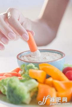 人,食品,生活方式,飲食,室內(nèi)_109437959_USA, New Jersey, Jersey City, Close-up view of woman hand putting baby carrot into dip_創(chuàng)意圖片_Getty Images China