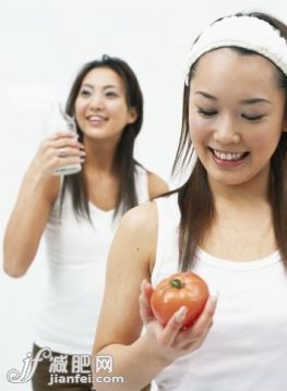 健康生活方式,健康保健,營(yíng)養(yǎng)品,飲食,健康食物_200328227-004_Two young women with bottle and tomato, smiling_創(chuàng)意圖片_Getty Images China