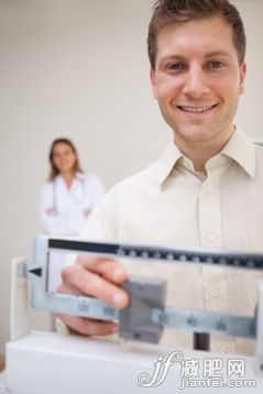 35歲到39歲,25歲到29歲,室內(nèi),白晝,門診部_gic9498705_Smiling man adjusting scale with doctor behind him_創(chuàng)意圖片_Getty Images China