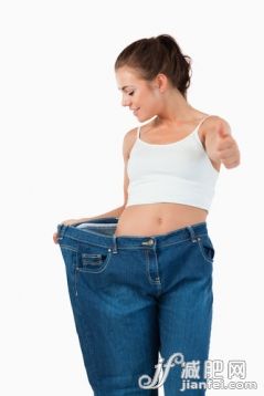 20到24歲,美女,美,肚子,衣服_gic9717290_Portrait of a thin woman wearing too large jeans with the thumb up against a white background_創(chuàng)意圖片_Getty Images China