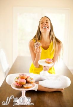 人,桌子,室內(nèi),25歲到29歲,快樂_163434288_Woman eating a donut_創(chuàng)意圖片_Getty Images China