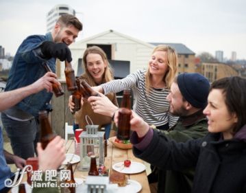 人,休閑裝,城市,桌子,瓶子_168595519_Toasting drinks around table in urban roof garden._創(chuàng)意圖片_Getty Images China